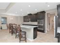 Modern kitchen with a granite island, stainless steel oven, and dark cabinets at 33161 Kateland Dr, Wesley Chapel, FL 33545