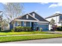 Beautiful two-story home with blue exterior, gray roof, and landscaped yard at 1570 Fox Grape Loop, Lutz, FL 33558