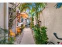 Landscaped walkway with tropical plants and orange umbrella at 818 Via Tripoli, Punta Gorda, FL 33950