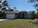 Lovely single-story home with a well-manicured lawn and a two-car garage at 135 Sunset Rd, Rotonda West, FL 33947
