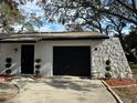 Black garage door and white stone accent wall at 198 Tulsa Ave, Spring Hill, FL 34606