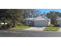 One-story house with tile roof, attached garage, and neatly landscaped yard at 1287 Lakeside Woods Dr, Venice, FL 34285