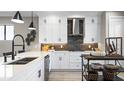 Modern kitchen with white cabinets, quartz countertops and a large island at 14370 Hammock Oak St, Parrish, FL 34219