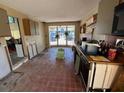 A fixer-upper kitchen with red tile floors and an abundance of natural light at 16211 3Rd E St, Redington Beach, FL 33708