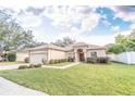 One-story house with a red door and attached garage, nestled on a spacious lawn at 12908 Cattail Shore Ln, Riverview, FL 33579