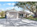 Newly renovated tan house with a brown roof and attached garage at 7939 Riverdale Dr, New Port Richey, FL 34653