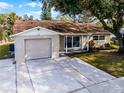 Newly renovated tan house with a brown roof and attached garage at 7939 Riverdale Dr, New Port Richey, FL 34653