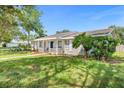 Single story home with a white picket fence porch, side lawn and colorful landscaping at 1390 Eastfield Dr, Clearwater, FL 33764