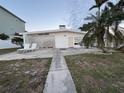 Rear view of the home showcasing a spacious patio and lawn area at 11240 6Th E St, Treasure Island, FL 33706