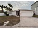 Mid-century modern home with attached garage and landscaped lawn at 11240 6Th E St, Treasure Island, FL 33706