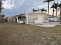 Side view of mid-century modern home with patio and lawn at 11240 6Th E St, Treasure Island, FL 33706