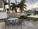 Waterfront patio with table and chairs, offering peaceful sunset views at 11240 6Th E St, Treasure Island, FL 33706