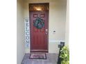 Red front door with a welcome wreath and mat at 109 Tierra Verde Way, Bradenton, FL 34212