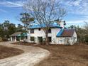 Two-story house with blue roof, tree, and curved driveway at 37921 Tiffany Rd, Dade City, FL 33525