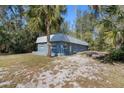 Blue house with metal roof and yellow door at 5117 Behms Ct, Port Richey, FL 34668