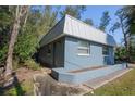 Side view of blue house with metal roof at 5117 Behms Ct, Port Richey, FL 34668