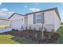 Newly built home with gray shutters, stone accents, and a two-car garage at 14109 Gunnison Cv, Parrish, FL 34219