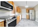 Kitchen with stainless steel appliances and wood cabinets at 2315 Snowflake Ln, North Port, FL 34286