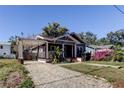 Gray bungalow with a brick driveway and lush landscaping at 7108 N 10Th St, Tampa, FL 33604