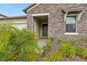 Front entry with stone facade and landscaping at 8796 Little Bluestem Dr, Land O Lakes, FL 34637