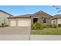 Two-story home with stone facade and three-car garage at 8796 Little Bluestem Dr, Land O Lakes, FL 34637