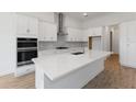 Modern kitchen featuring white cabinets, quartz countertops, and stainless steel appliances at 1003 Signet Dr, Apollo Beach, FL 33572