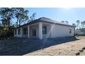 New construction home showcasing its rear elevation, covered patio and neutral color scheme at 1504 Kohlenberg Ave, North Port, FL 34288