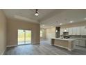 Open-concept living room with gray wood-look floors and neutral-toned walls at 1504 Kohlenberg Ave, North Port, FL 34288