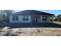 Newly built home with covered patio, neutral stucco exterior and dark trim at 1504 Kohlenberg Ave, North Port, FL 34288