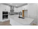 Modern kitchen with white shaker cabinets, quartz countertops and black hardware at 1017 Signet Dr, Apollo Beach, FL 33572