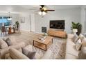 Bright and airy living room features neutral decor, comfy seating, and a large TV at 1414 Wickham Ln, Holiday, FL 34691
