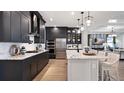Spacious kitchen featuring dark cabinetry, quartz countertops, and stainless steel appliances at 14451 Coastal Woodland Ln, Parrish, FL 34219