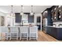 Modern kitchen with an island, white quartz countertops and dark cabinetry at 14451 Coastal Woodland Ln, Parrish, FL 34219
