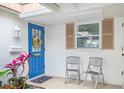 Inviting front entry with blue door and two chairs at 2322 Riverbluff Pkwy # V250, Sarasota, FL 34231