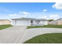 House with a white exterior, attached garage, and a neatly landscaped lawn at 4406 Woodtrail Blvd, New Port Richey, FL 34653