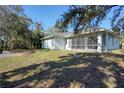 Landscaped backyard with screened porch and large grassy area at 2559 Comet Ln, North Port, FL 34286