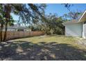 Large side yard with wooden fence and mature trees at 2559 Comet Ln, North Port, FL 34286