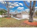 Tan house with white garage door and mature trees at 6201 Cedarbrook N Dr, Pinellas Park, FL 33782