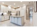 Eat-in kitchen with white cabinets, granite island, and stainless steel appliances at 8726 Terracina Lake Dr, Tampa, FL 33625