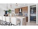 Modern kitchen with island seating, wood cabinets, and walk-in pantry at 14517 Coastal Woodland Ln, Parrish, FL 34219