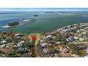 Aerial view of waterfront property with private dock and lush landscaping at 103 Shore Dr, Dunedin, FL 34698