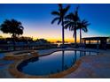 Inviting freeform pool with spa and patio overlooking the water at 103 Shore Dr, Dunedin, FL 34698