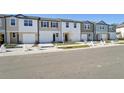 Row of townhouses showcasing attached garages and neat landscaping at 11873 Sylvia St, Dade City, FL 33525