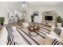 Bright living room with hardwood floors, comfy sofas, and built-in shelving at 7224 Highland Loop, Zephyrhills, FL 33541