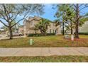 Tan townhome with a green lawn and trees at 1006 Vista Cay Ct, Brandon, FL 33511