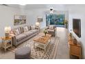 Bright living room with comfy seating, large TV, and sliding glass door to balcony at 705 S Village N Dr # 205, St Petersburg, FL 33716