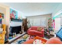 Living room features a fireplace and coral couch at 2101 Sunset Point Rd # 2304, Clearwater, FL 33765