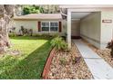 House entrance with walkway, landscaping, and mature trees at 3534 Player Dr, New Port Richey, FL 34655