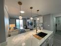 Open concept kitchen with white cabinets and gold accents at 750 N Tamiami Trl # 814, Sarasota, FL 34236