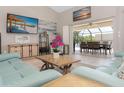 Spacious living area with light teal sofas, a large TV, and views of the pool at 2917 Palm Dr, Punta Gorda, FL 33950